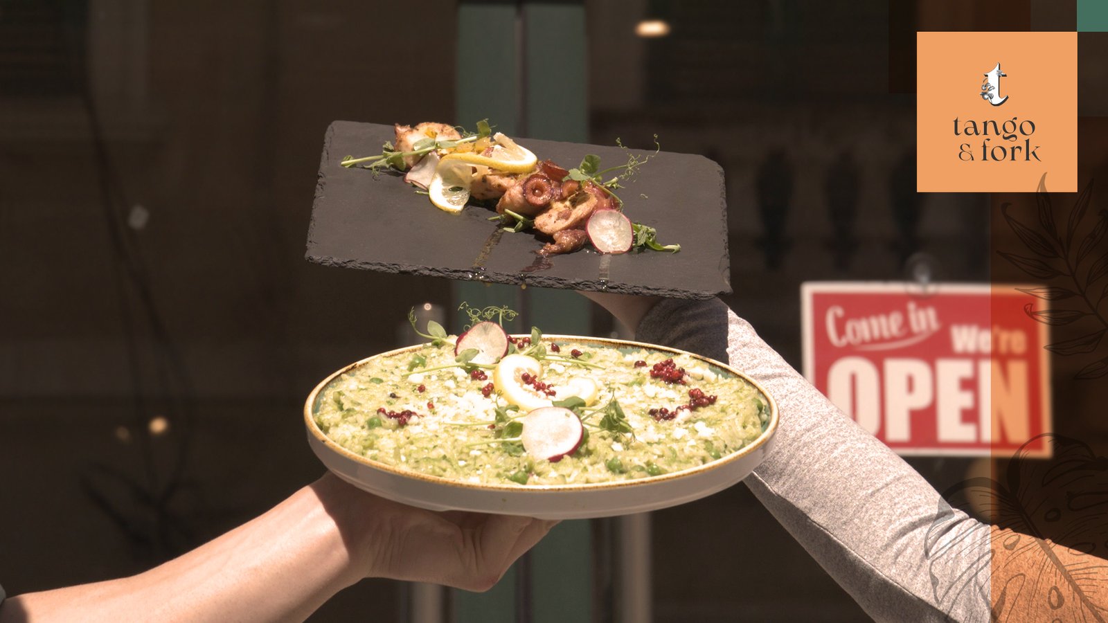 A plate with food standing in front of Tango & Front entrance