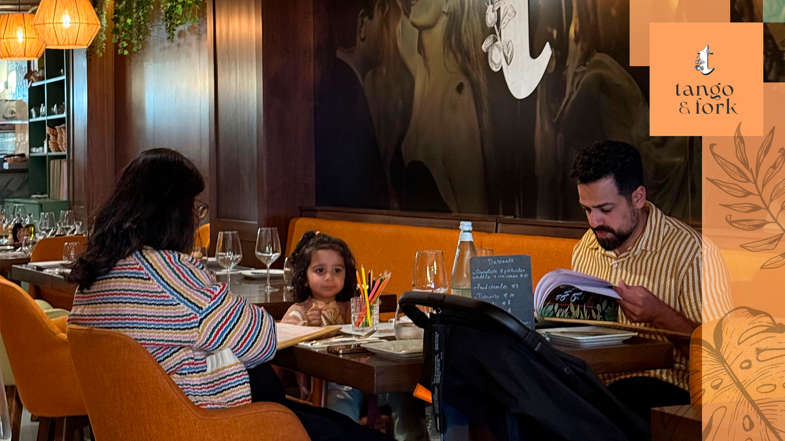 Family dining at Tango & Fork restaurant with parents and child reviewing menu at table